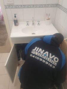 Jinavo team fixing emergency bathroom water leak - Arden Street, North Melbourne